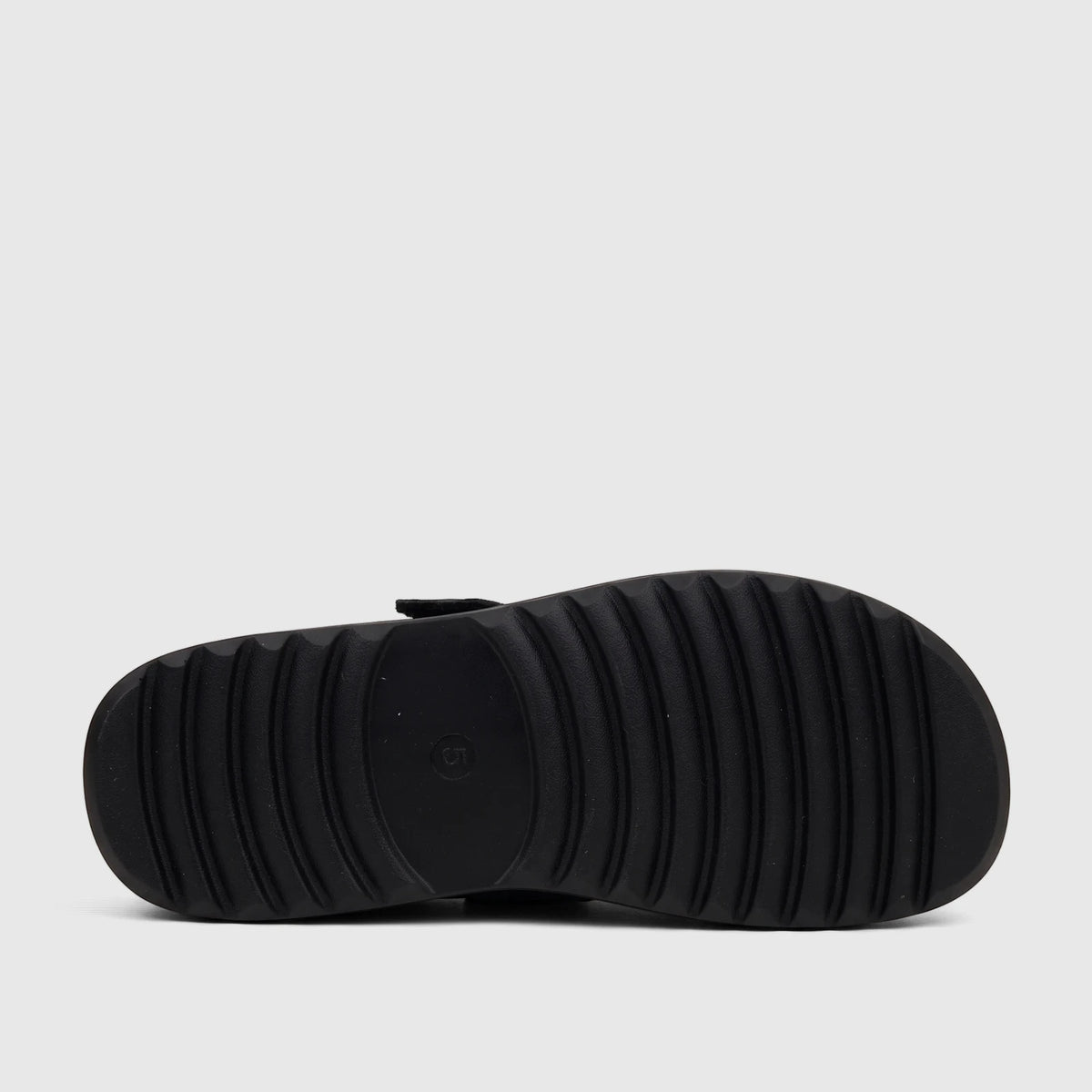 Bottom view of a black Hush Puppies Noelle Ladies Comfort Clog, showcasing its deep ribbed outsole and sturdy construction.