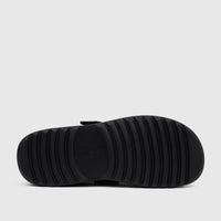 Bottom view of a black Hush Puppies Noelle Ladies Comfort Clog, showcasing its deep ribbed outsole and sturdy construction.