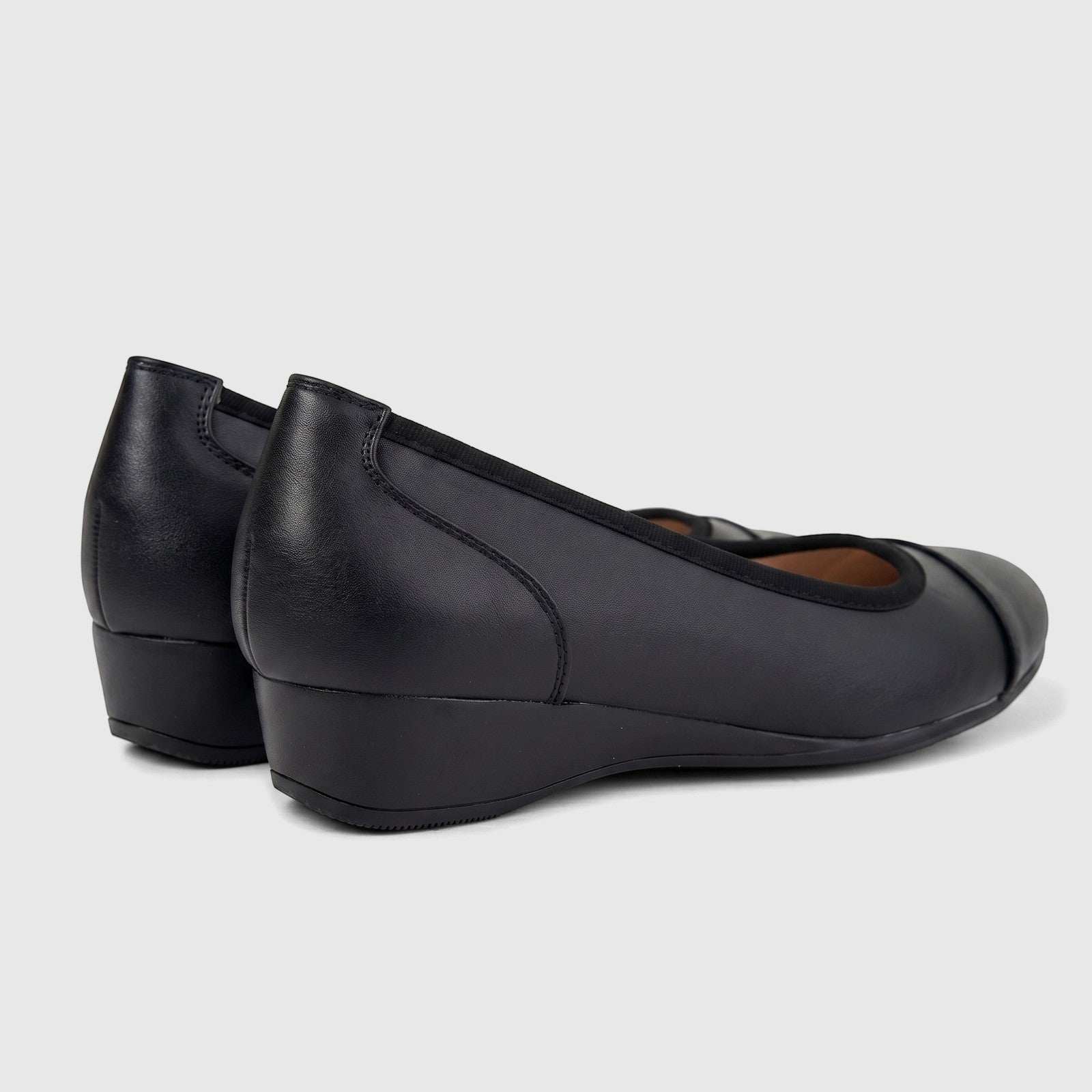 Pair of black leather Hush Puppies Rishelle Mono wedge pumps, seen from a rear-side angle, showcasing the comfortable design.