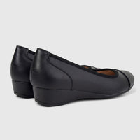 Pair of black leather Hush Puppies Rishelle Mono wedge pumps, seen from a rear-side angle, showcasing the comfortable design.
