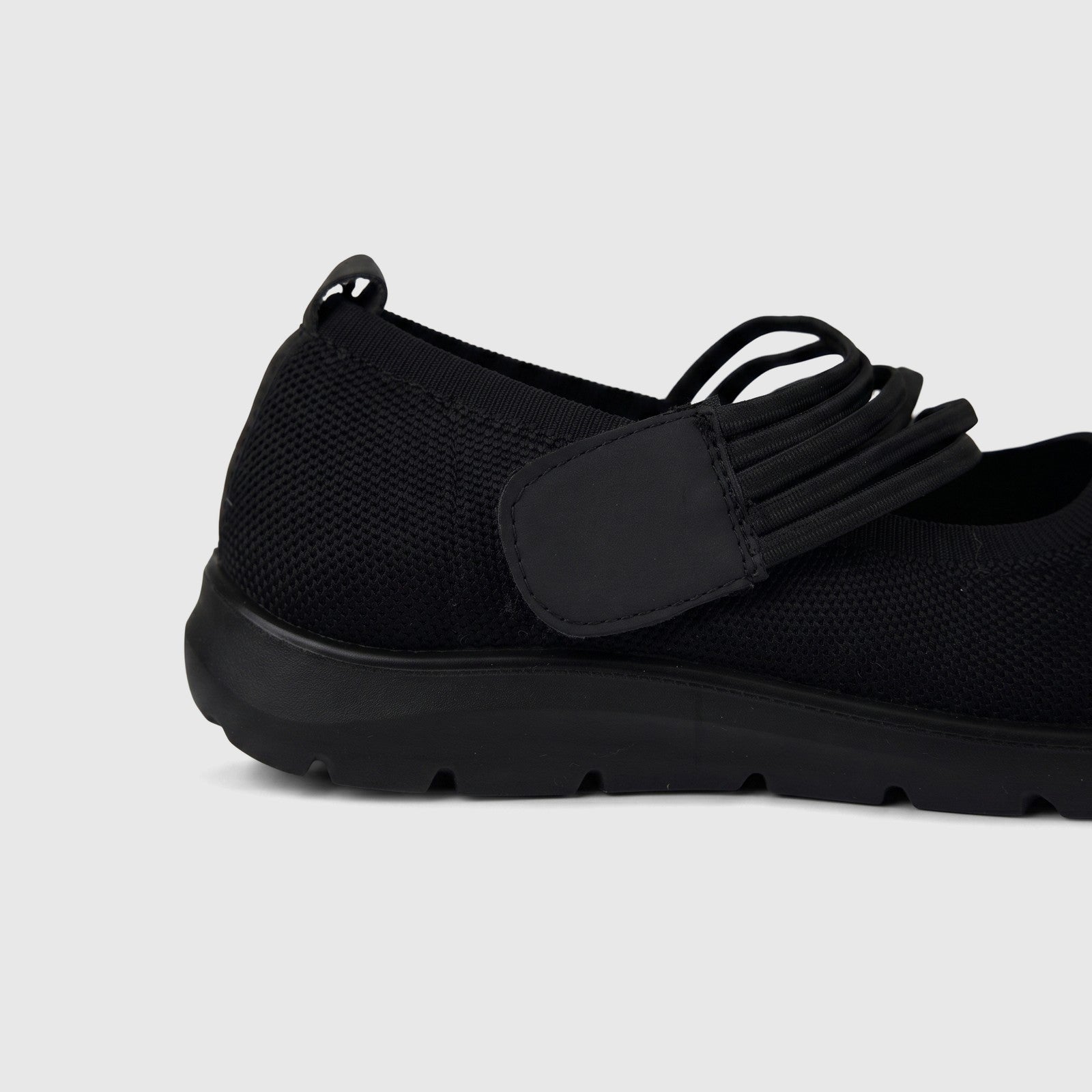 Hush Puppies Soft Style Soft Bartan ladies comfort pump in black with textured knit upper and elastic strap, side view.