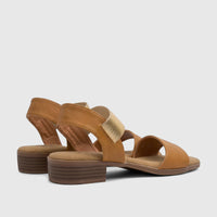 A pair of tan Hush Puppies Soft Style Harlan comfort sandals for ladies, featuring gold elastic straps and a low heel.