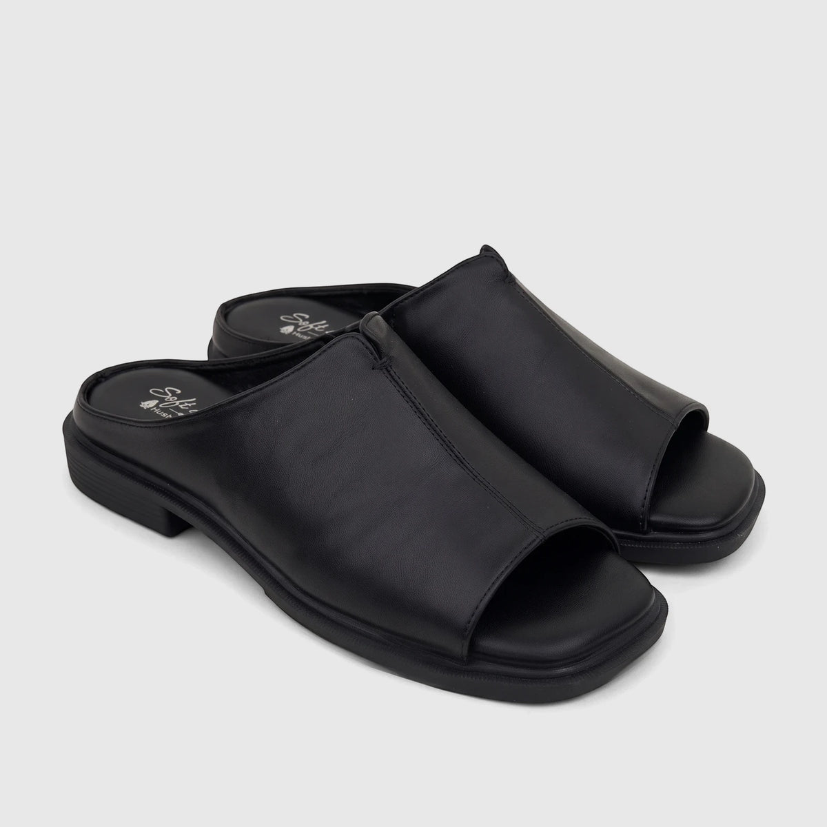 Pair of black Hush Puppies Soft Style Ladies Comfort Sandal Kathan SSL01677, open-toe slip-on style on a white background.