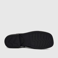 Bottom view of a Hush Puppies Soft Style ladies' black comfort sandal, showcasing the durable sole with intricate tread