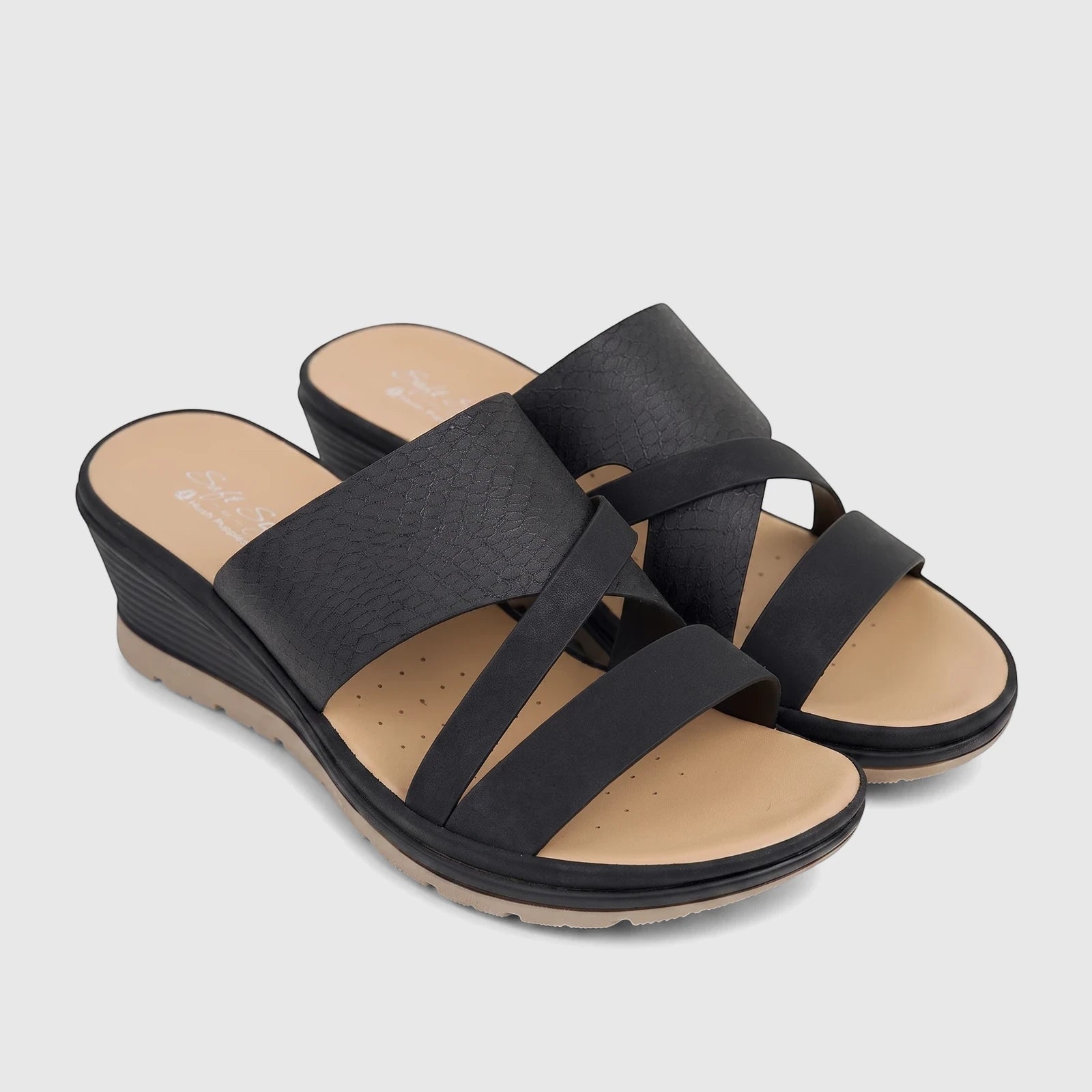A pair of black Hush Puppies Soft Style wedge slide comfort sandals with criss-cross straps and a tan footbed.