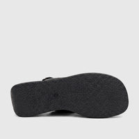 Bottom view of a black Hush Puppies Soft Style ladies' comfort wedge shoe, showcasing the textured sole and sturdy design.