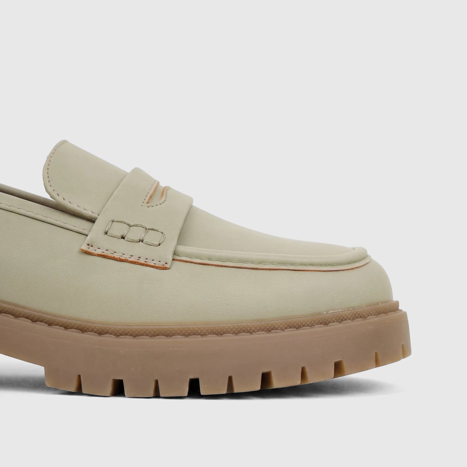 Close-up of a single Hush Puppies Soft Style Ladies Loafer in light sage, featuring a penny slot detail and a thick brown