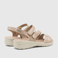 Light gold Hush Puppies Soft Style Ogillian comfort sandals with a textured upper and white platform soles, shown from a