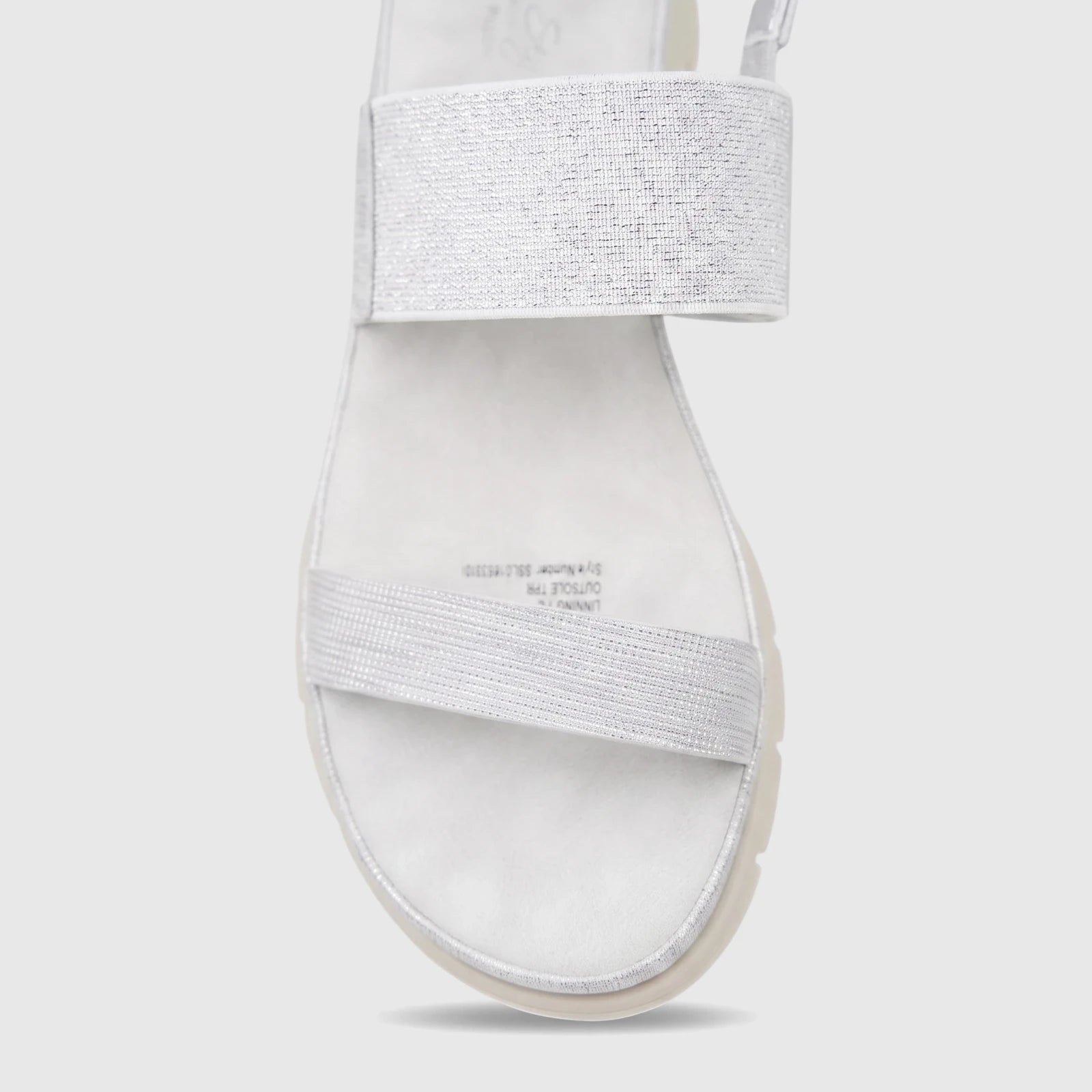 Hush Puppies Soft Style Telina ladies comfort sandal in silver with shimmering elastic straps and a flat sole, close up view.