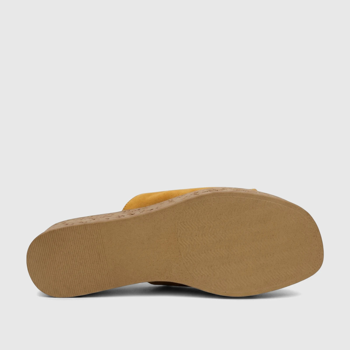 Underside view of a yellow Hush Puppies Soft Style ladies comfort wedge sandal, featuring a textured brown sole.