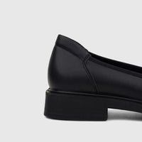 Hush Puppies Valonia black leather comfort pump for ladies, showing the heel and side view on a white background.