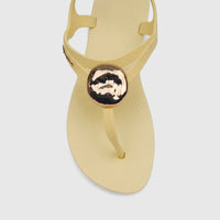 Top-down view of an Ipanema Class Daring Sandal in yellow gold, featuring a large metallic embellishment on the strap.