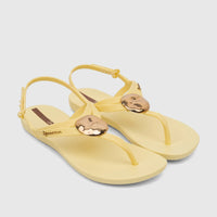 Pair of Ipanema Class Daring sandals in yellow with gold-tone metallic thong strap embellishments, shown from a slightly