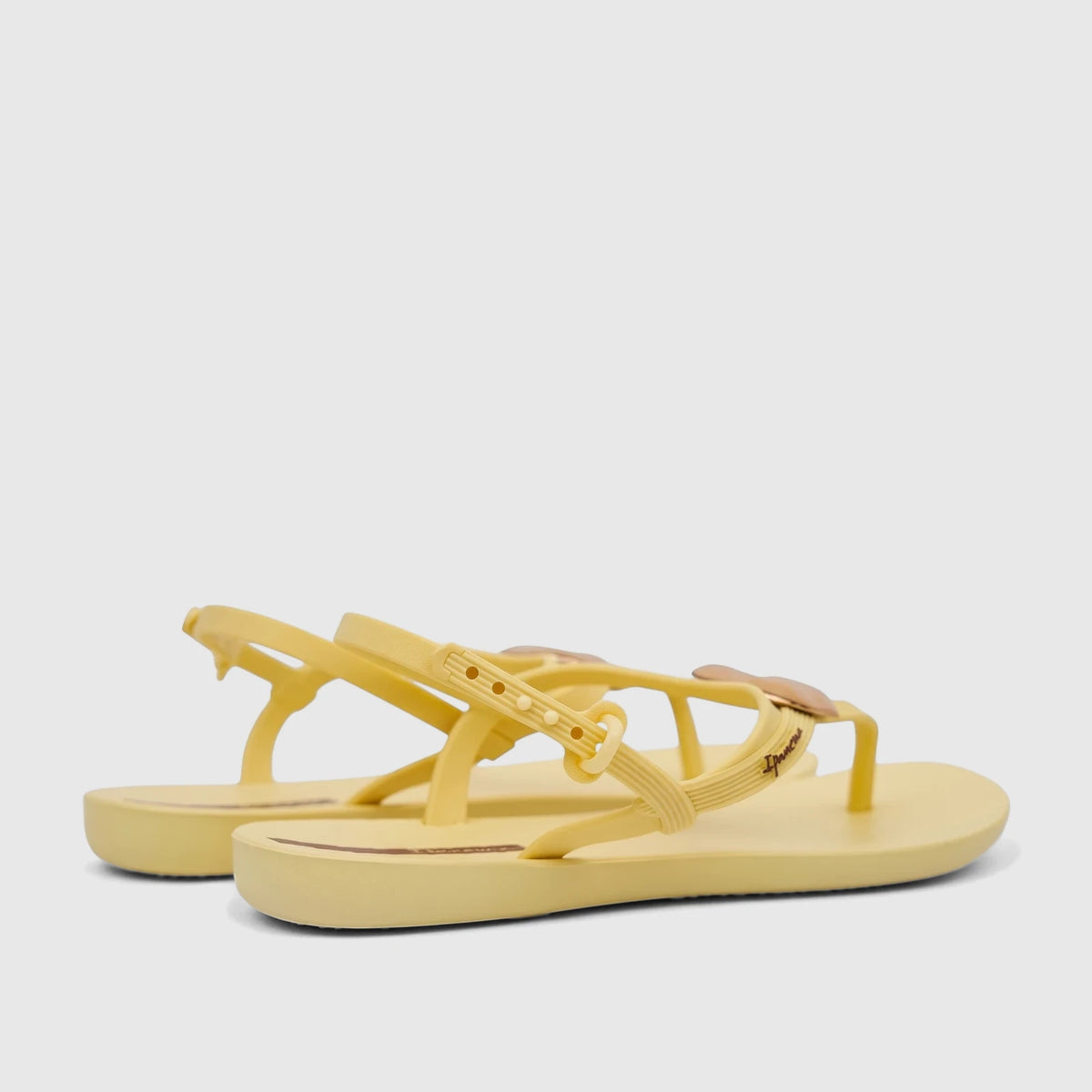Pair of Ipanema Class Daring women's sandals in yellow gold, featuring a sleek design with ankle straps, presented in a side