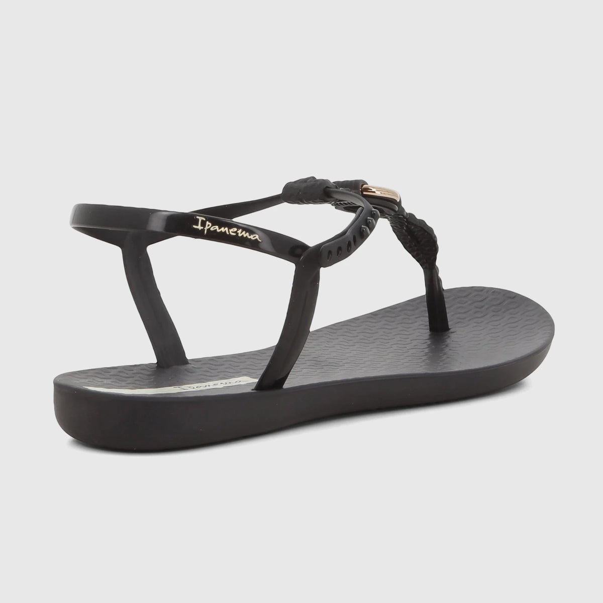 Black Ipanema Class Luma thong sandal with gold detail, viewed from an angled rear perspective.