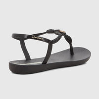 Black Ipanema Class Luma thong sandal with gold detail, viewed from an angled rear perspective.