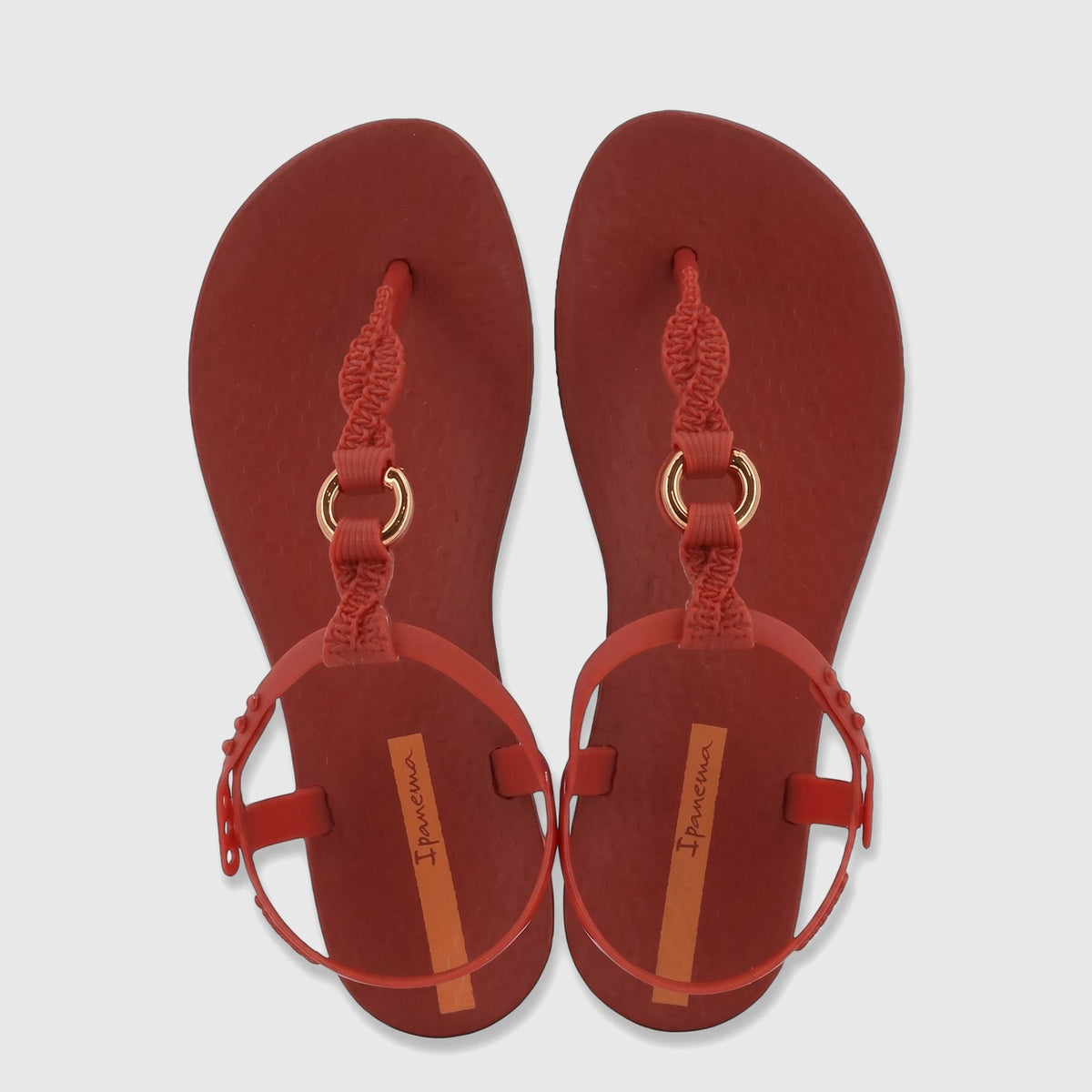 Ipanema Class Luma sandals in red with braided T-strap and gold-tone rings, presented from a top-down view.