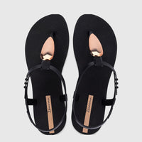 A pair of Ipanema Class Luxury GIL83954 flat sandals in black with shiny gold metallic teardrop accents, shown in a top-down