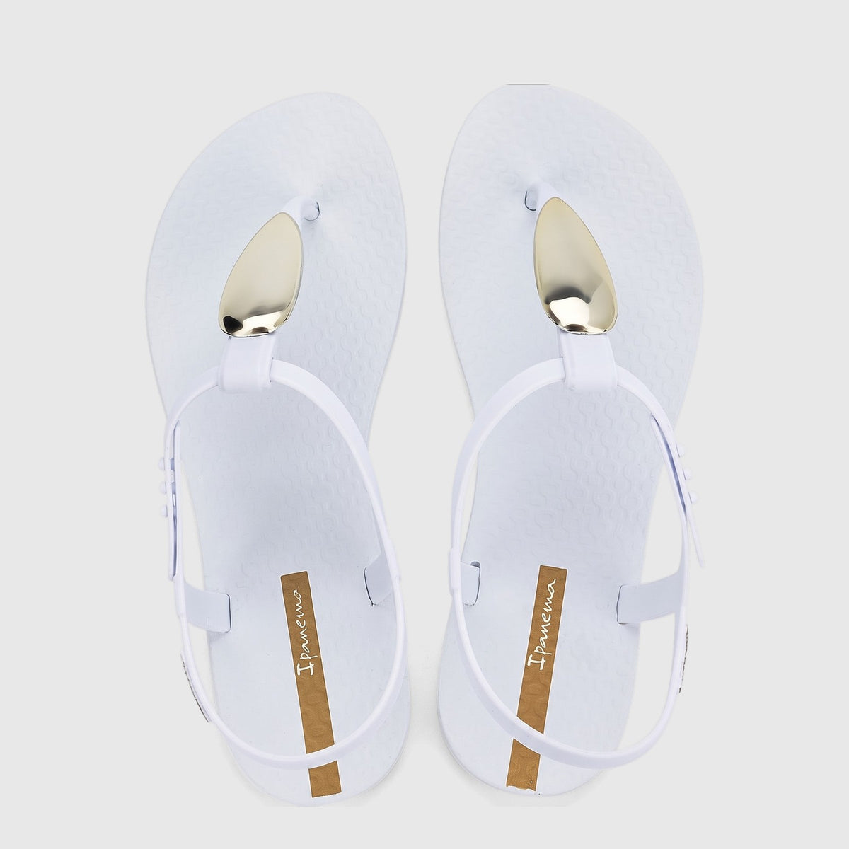 White Ipanema Class Luxury sandals with gold-tone oval hardware and ankle straps, shown from a top-down view.