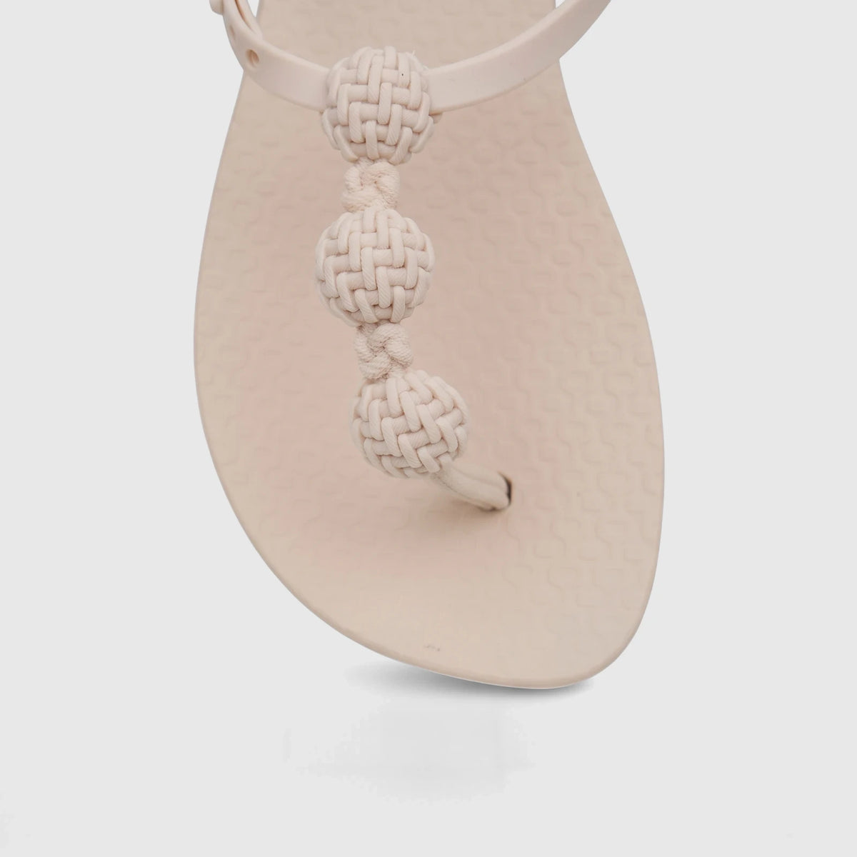 Close-up of a beige Ipanema Class Posh Sandal GIL83956 with a toe-post strap featuring three decorative woven knots.
