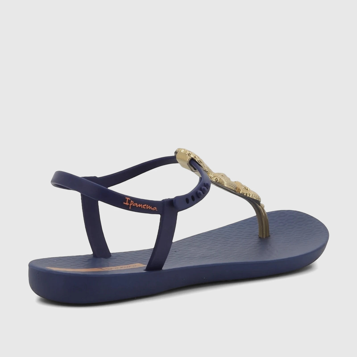 Ipanema Fundo Do Mar Sandal in blue with a gold shell-embellished strap, shown from a side angle.