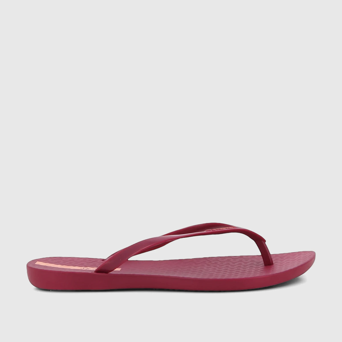 Ipanema Wave Fem GIL25971 burgundy patent flip-flop, side view, with a textured sole and thin strap.
