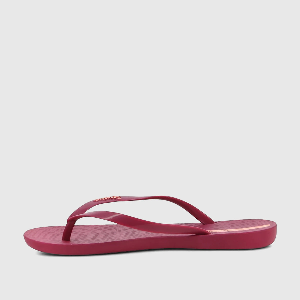 Ipanema Wave Fem GIL25971 burgundy patent flip-flop, featuring a slim strap with a logo and wavy textured insole, side view.
