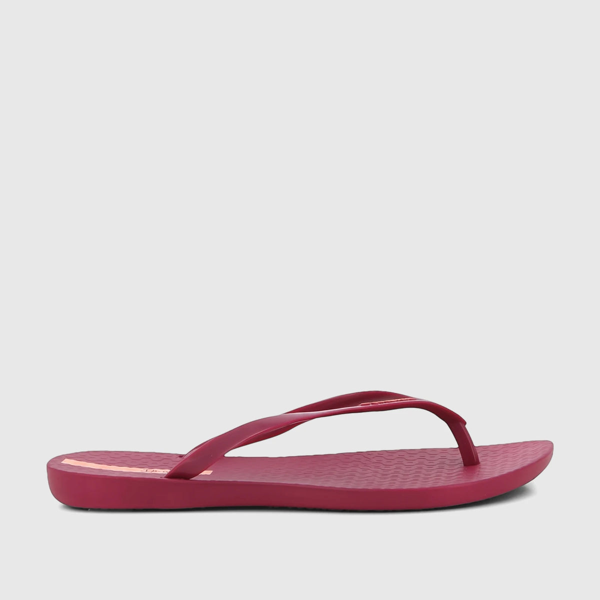 Ipanema Wave Fem burgundy patent flip-flop, featuring textured sole and narrow straps, shown from a side profile.