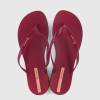 Pair of Ipanema Wave Fem GIL25971 burgundy patent flip-flops, featuring gold branding on straps and heel labels, viewed from