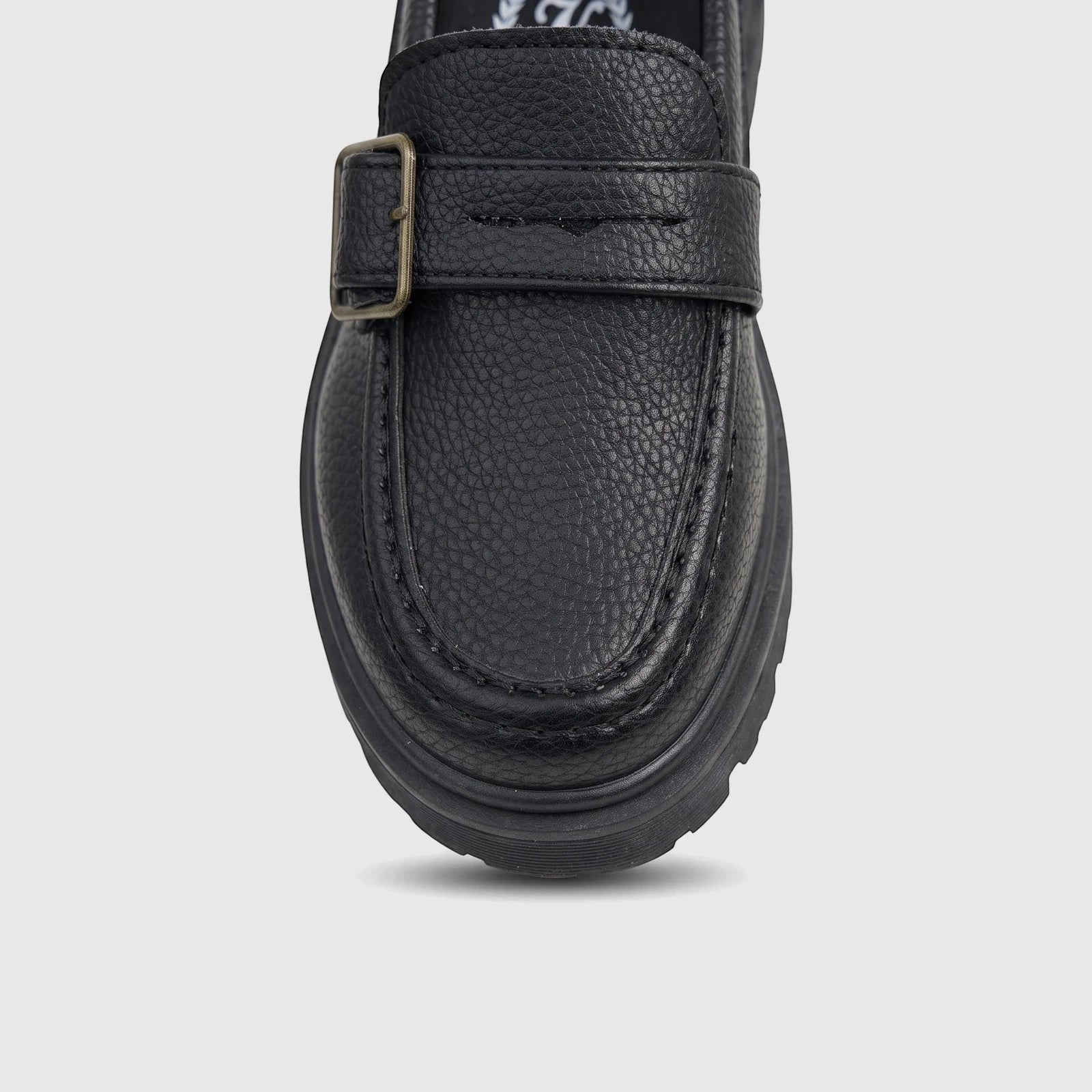 Close-up of a Klevas Boys black chunky sole loafer with a monk strap, brass buckle, pebbled faux leather, and a thick lug