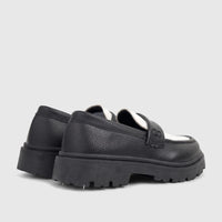 Pair of Klevas Boys chunky sole loafers in black and white, viewed from the back-side, showcasing their textured leather and