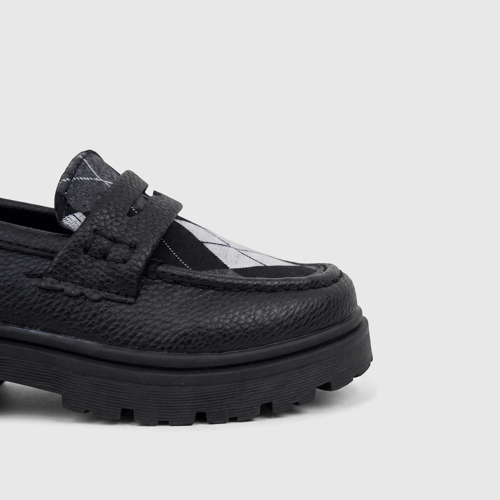 Klevas Boys black chunky sole loafer, featuring a textured upper and a black and white argyle pattern on the vamp.