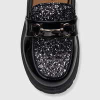 Klevas Boys chunky sole loafer in casino black patent leather with silver glitter details and horsebit hardware, close-up