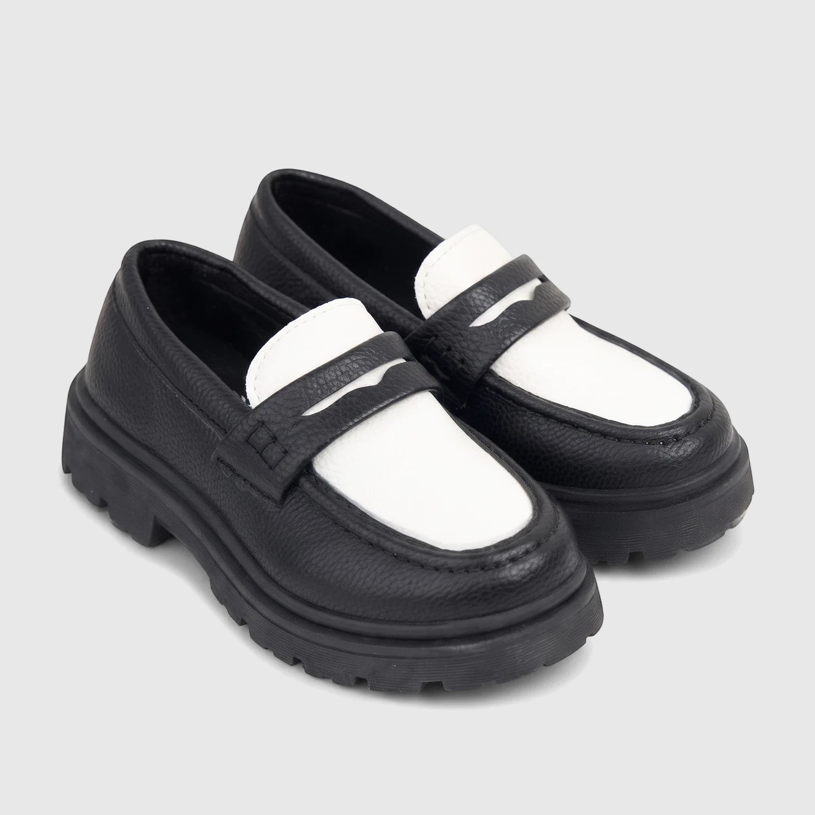 Pair of Klevas Boys Chunky Sole Loafers in black and white, featuring a lug sole, presented at an angle.