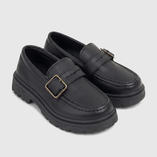 Black Klevas Boys chunky sole loafer with a monk strap buckle, featuring a pebbled texture, viewed from the side.
