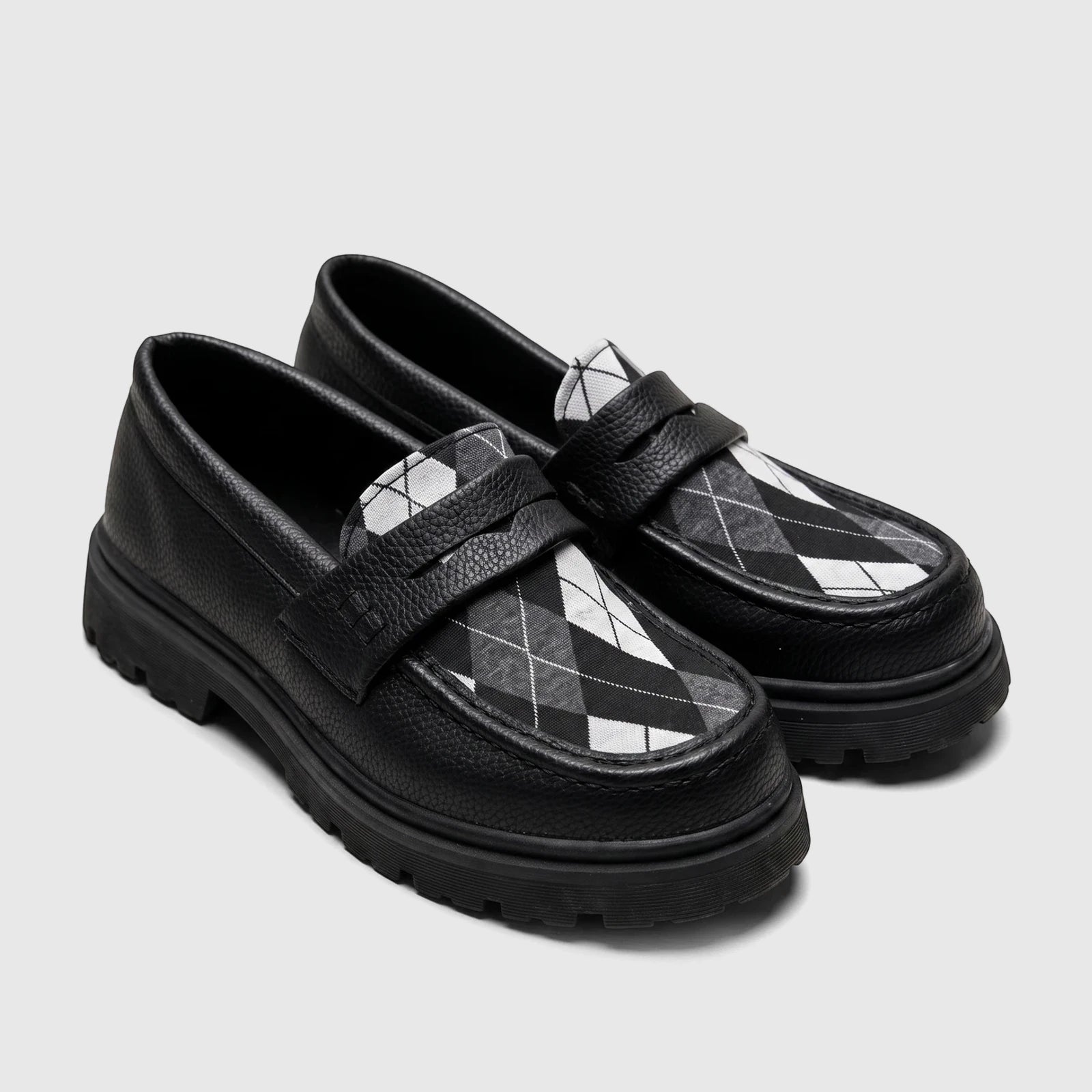 Pair of Klevas Boys Youth chunky sole loafers in black pebbled leather with a black and white argyle pattern on the vamp,