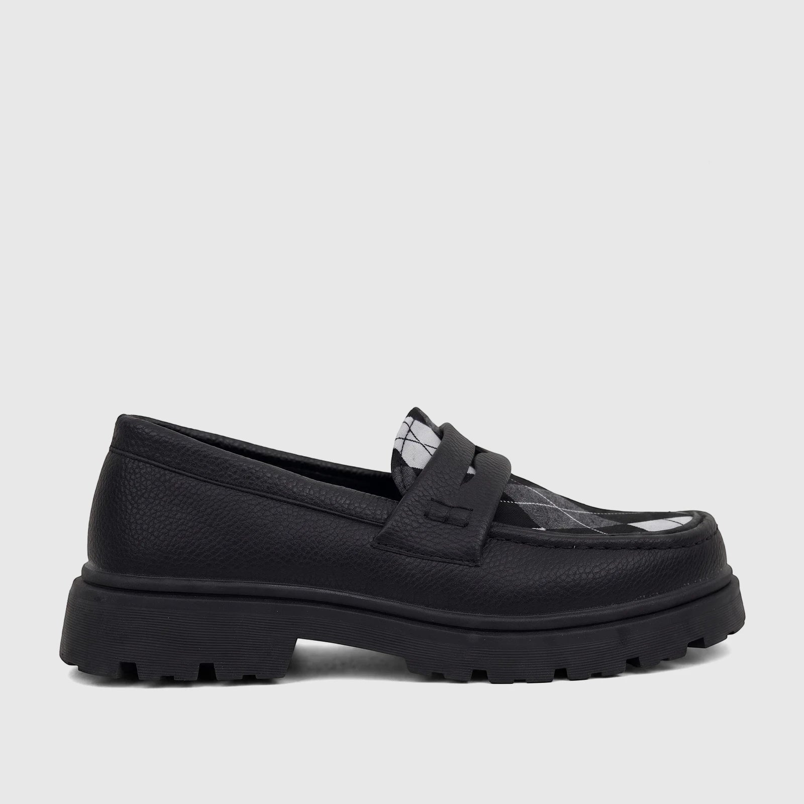 A side view of a Klevas black chunky sole loafer for boys, featuring a textured upper and a black and white argyle pattern