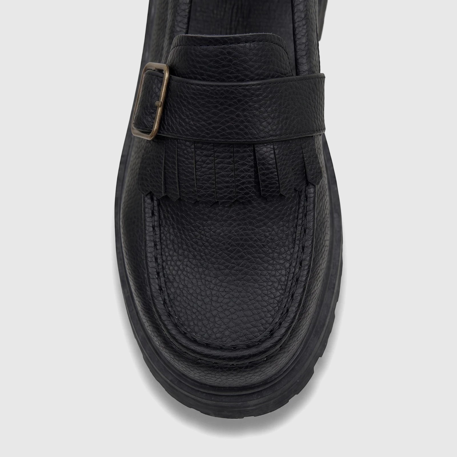 Front view of Klevas Boys Youth chunky sole loafer in black with a metallic buckle and fringe detail.