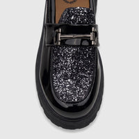 A close-up of a Klevas Boys Youth chunky sole loafer in casino black patent leather with sparkling glitter detail and a