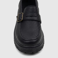 Close-up of a black textured leather Klevas youth chunky sole loafer with a monk strap and bronze buckle.