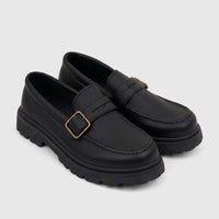 Two black Klevas Boys Youth chunky sole loafers featuring a pebbled texture and gold monk strap buckles, displayed from an