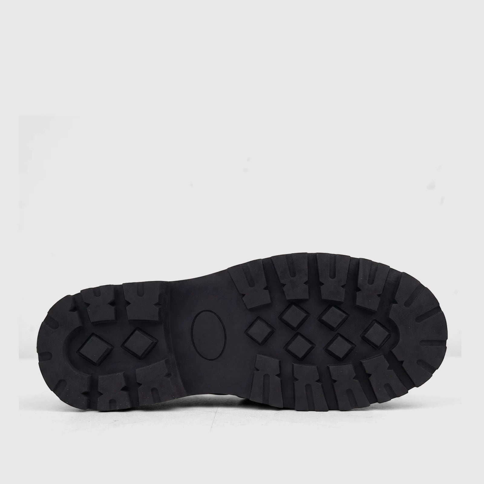 View of a black Klevas Boys Youth chunky sole loafer, showcasing the detailed rubber outsole tread pattern from below.