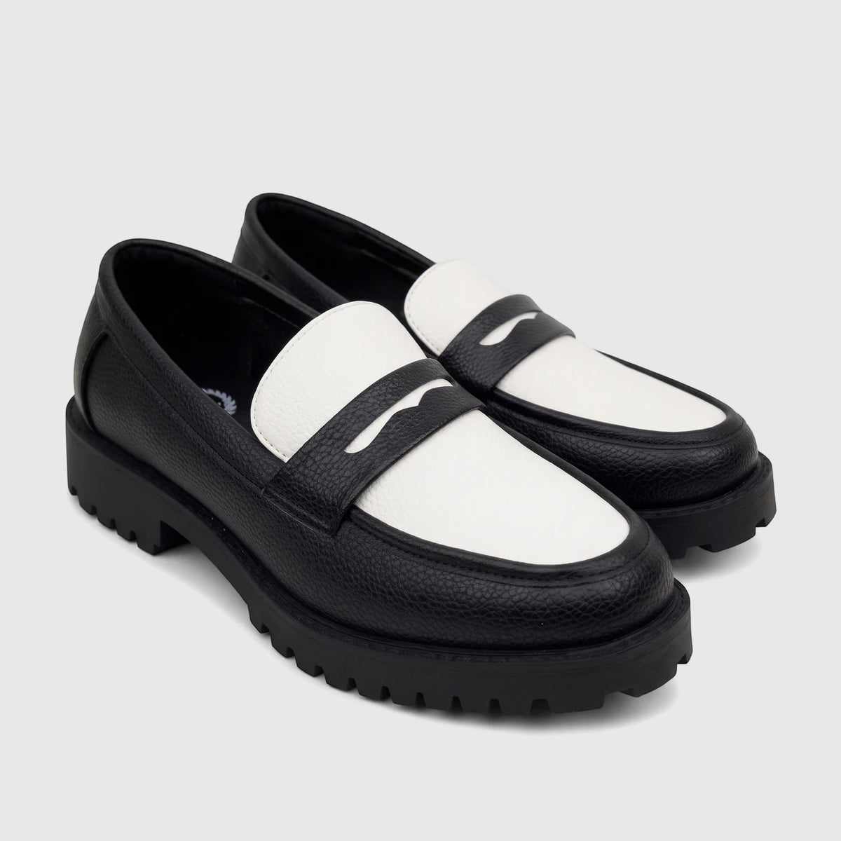 A pair of Klevas Men's Chunky Sole Loafers in black and white, featuring a pebbled texture and a wavy penny strap design.