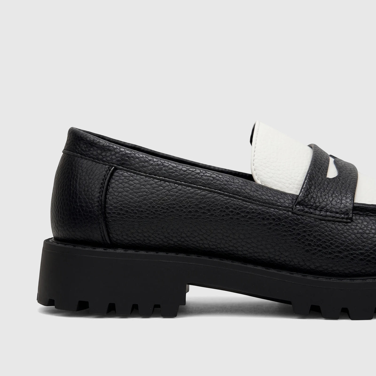 Close-up side view of a Klevas Men's Chunky Sole Loafer in black and white with a pebbled texture.