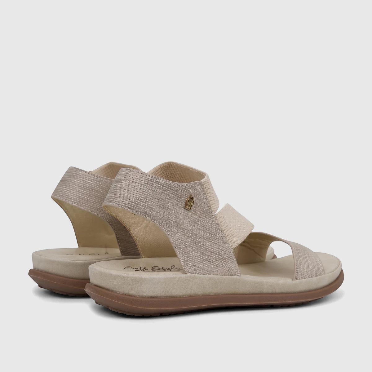 Pair of light gold Hush Puppies Soft Style Indy comfort sandals shown from a side view, featuring textured straps and a