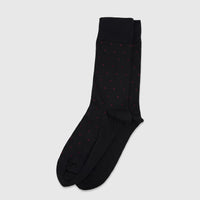 Pair of black men's micro modal socks with bordeaux red polka dots, displayed flat on a surface.