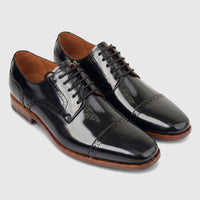 Men's black patent leather cap-toe Oxford dress shoes with brown soles and laces, presented side by side.