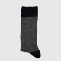 A single men's mercerised bamboo sock, black at the cuff and toe, with a grey diamond argyle pattern on the main body, laid