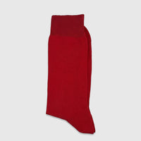 A pair of vibrant red men's mercerised cotton socks, folded neatly and displayed in a flat-lay studio shot.