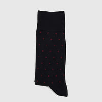A single black Men's Micro Modal Sock with red polka dots, folded and laid flat, from the Black Bordeaux collection.